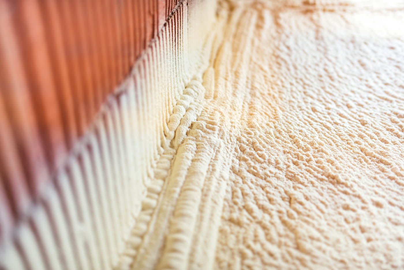 Spray foam being used on the inside of a wood floor, book with iFoam insulation company.