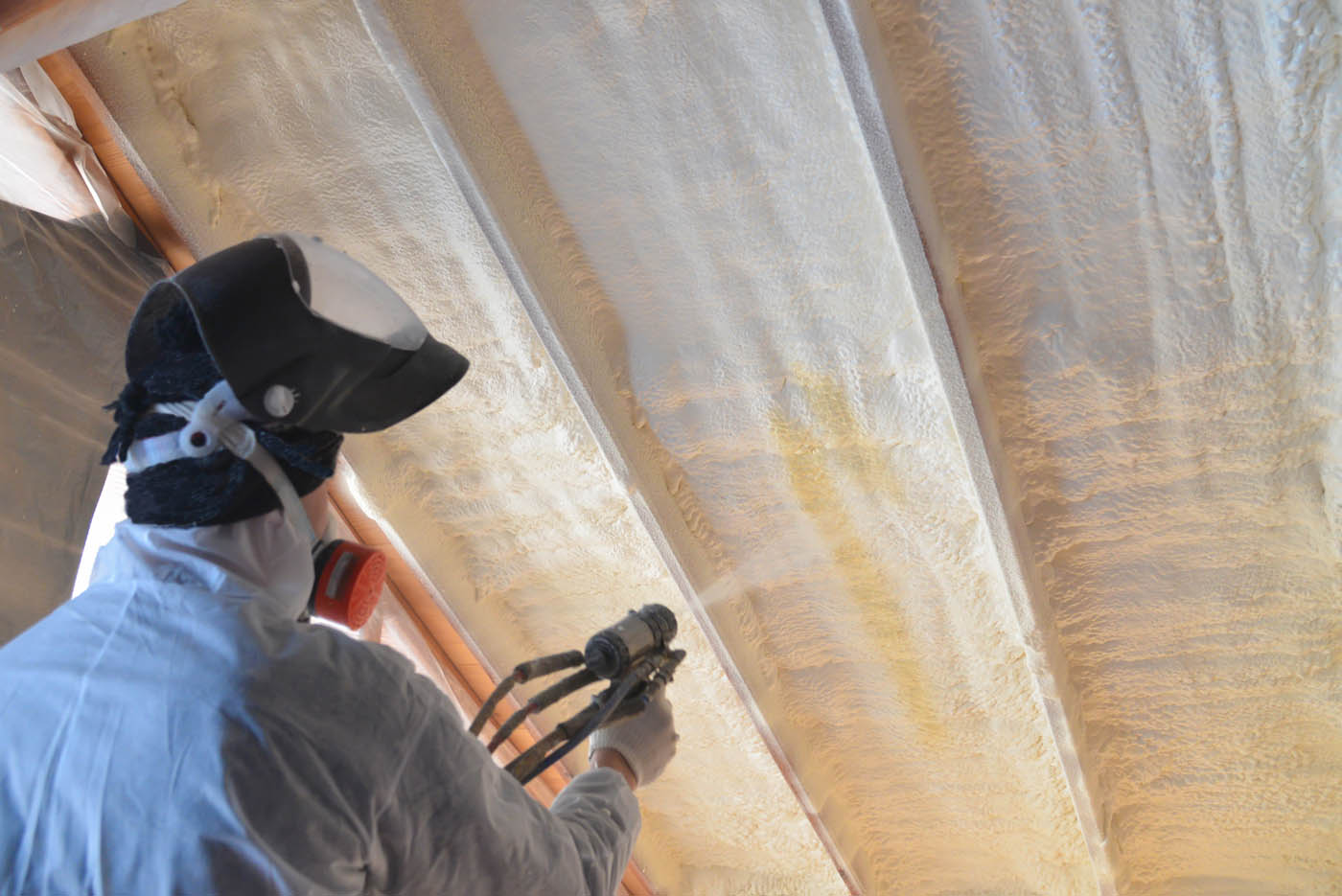 iFoam spray insulation installers working on a basement ceiling to improve heating and air efficency.